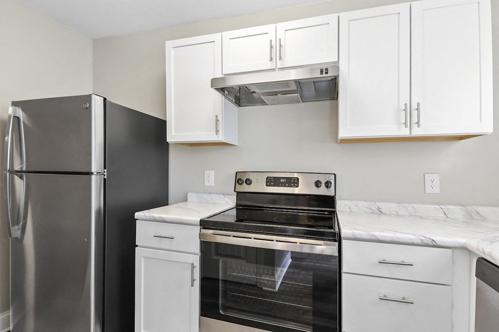a kitchen with white cabinets and stainless steel appliances