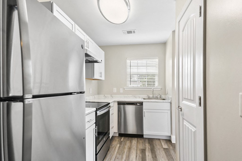 a kitchen with white cabinets and stainless steel appliances