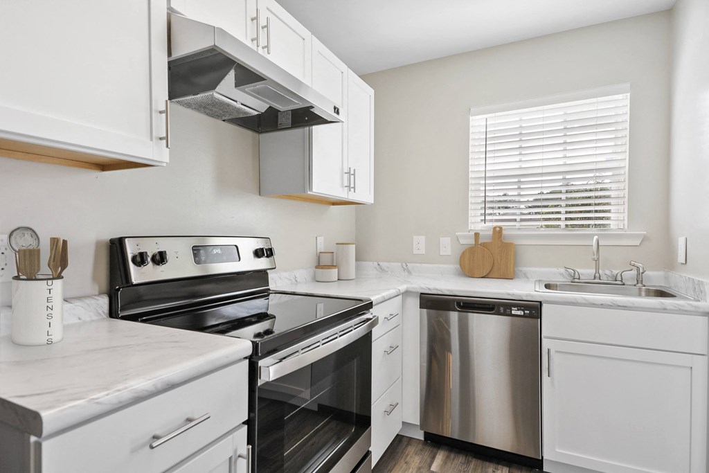 a kitchen with white cabinets and stainless steel appliances