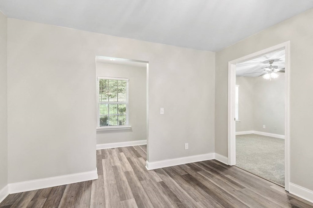 a bedroom with hardwood floors and a ceiling fan