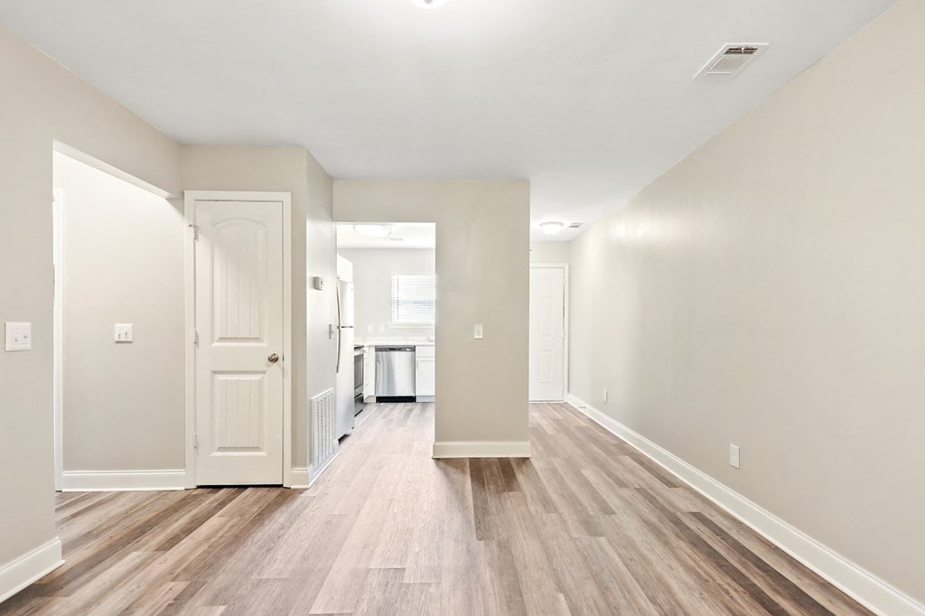 a bedroom with hardwood floors and white walls