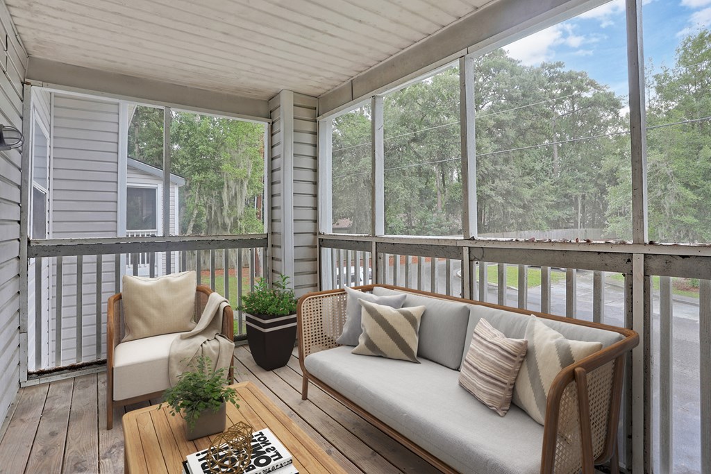 a screened in porch with a couch and chairs