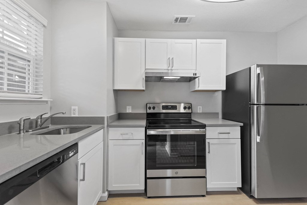 a kitchen with white cabinets and stainless steel appliances