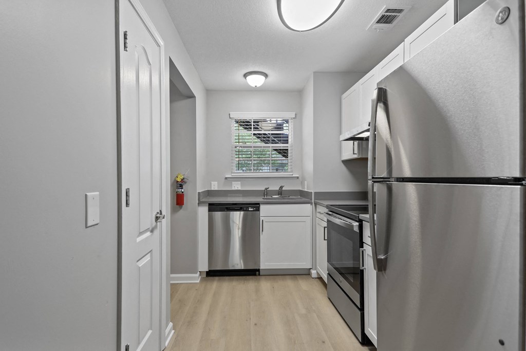 a renovated kitchen with stainless steel appliances and white cabinets