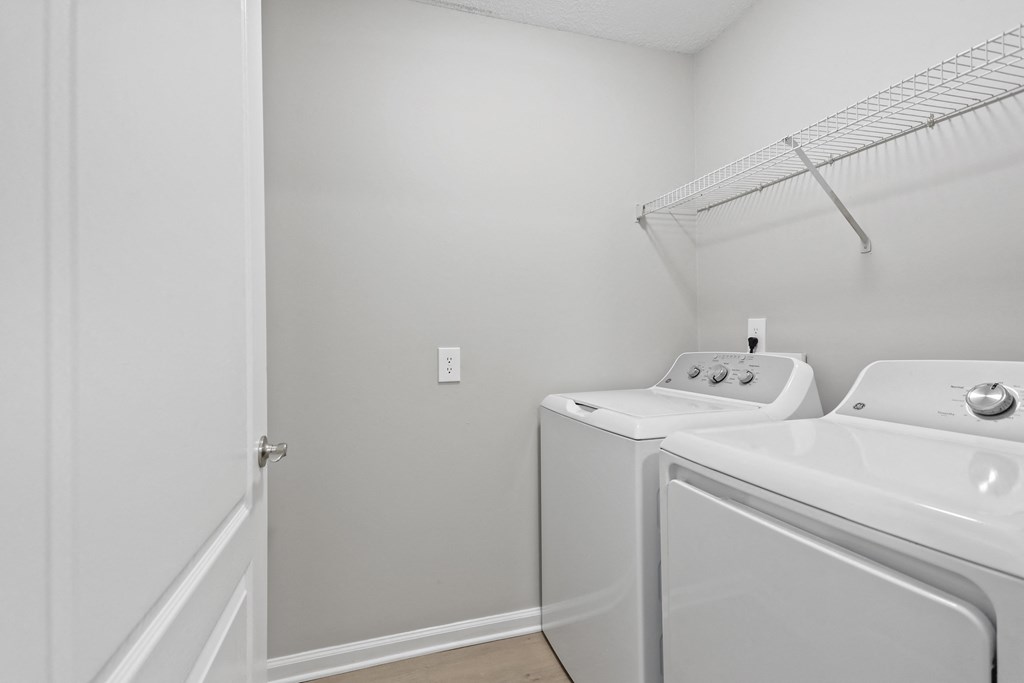 a laundry room with a washer and dryer and a door to a closet