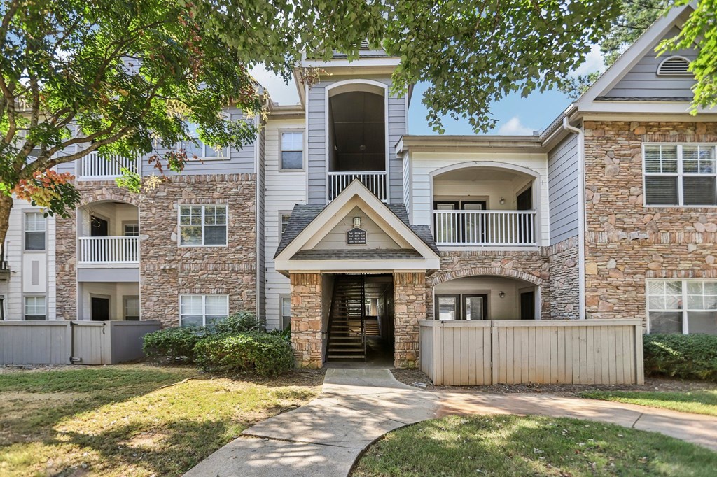 A large stone building with a balcony and a covered entrance.