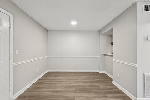 A room with wooden flooring and white walls.