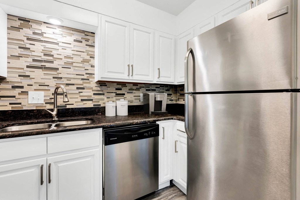 a kitchen with white cabinets and stainless steel appliances