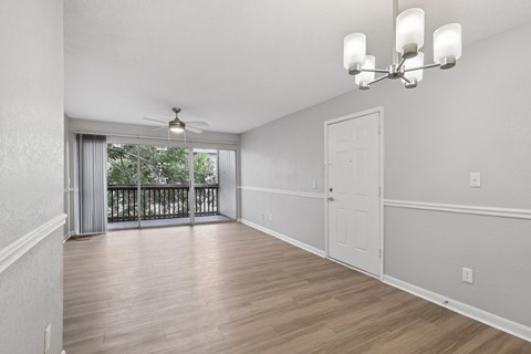 A room with a balcony and a ceiling fan.