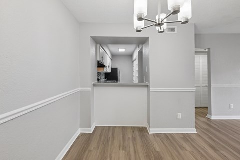 A room with a white wall and a wooden floor.