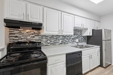 A kitchen with black and white appliances and cabinets.