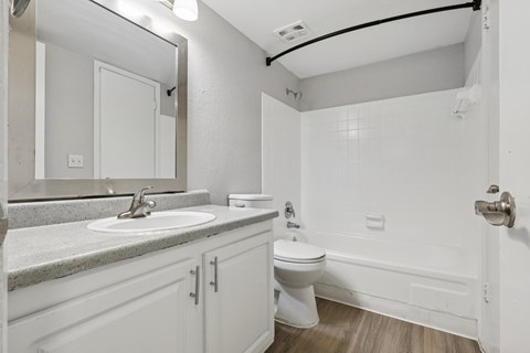 A white bathroom with a sink, toilet, and bathtub.