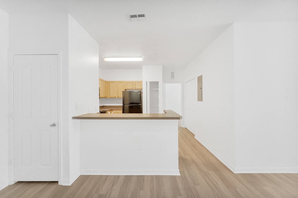 a kitchen with white walls and wood flooring