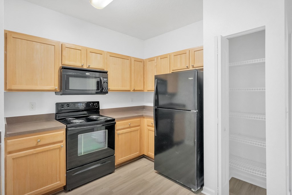 a kitchen with wood cabinets and black appliances