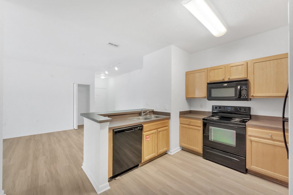a kitchen with wood flooring and wooden cabinets