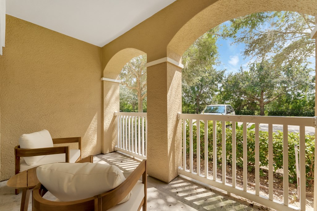 a balcony with two chairs and a table