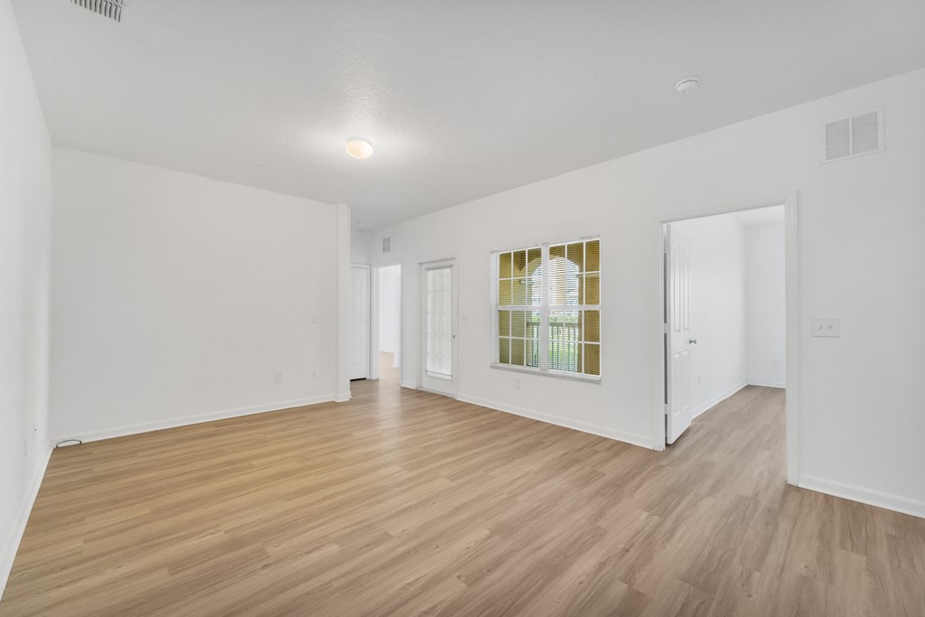 a bedroom with hardwood floors and white walls