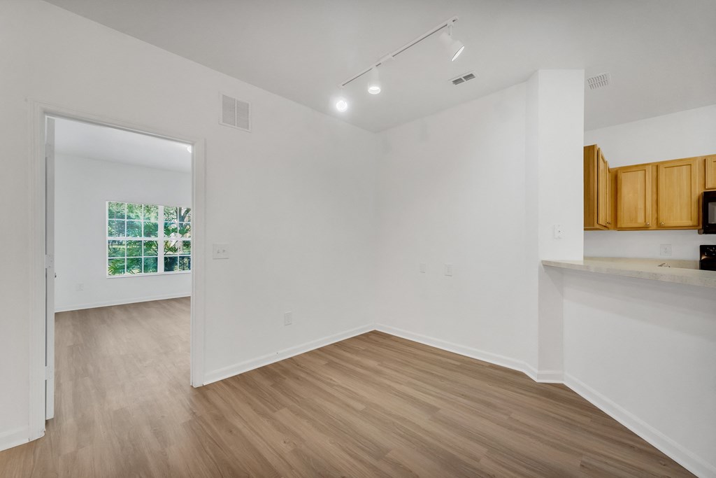 a bedroom with hardwood floors and white walls