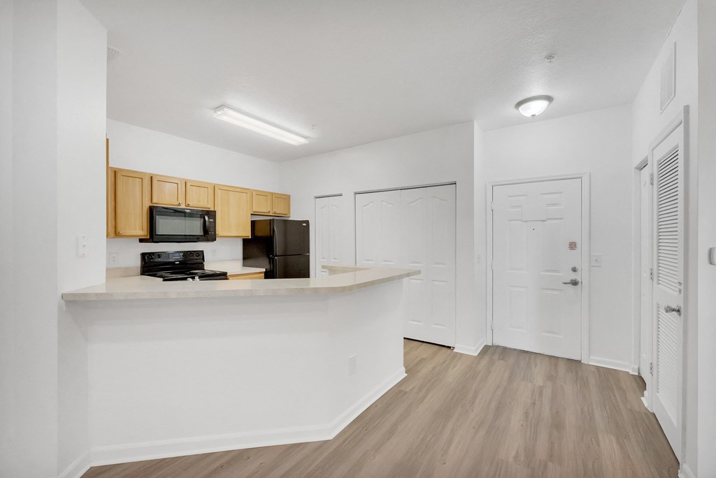 a kitchen with wood floors and white walls