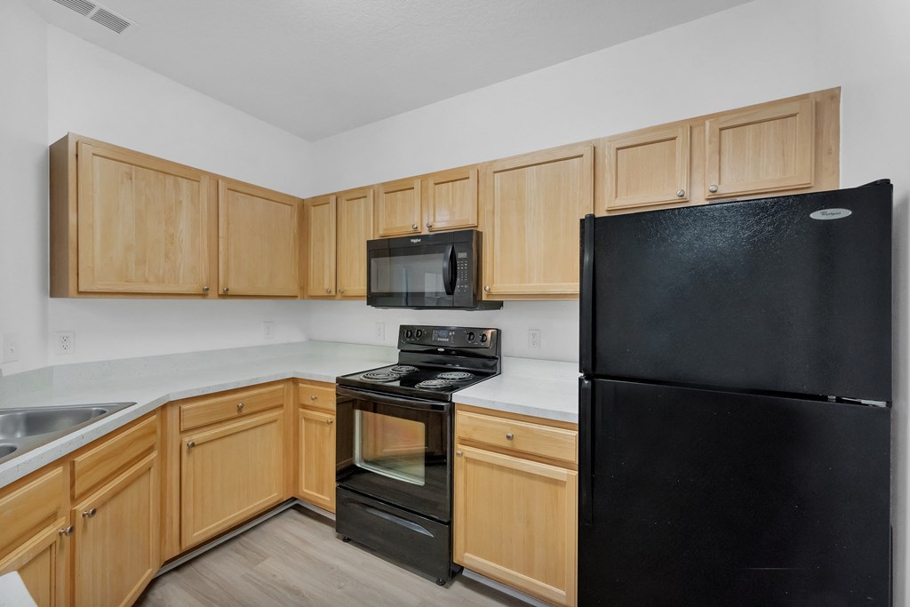 a kitchen with wood cabinets and black appliances