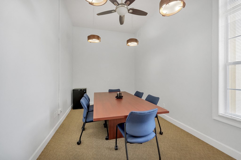 a meeting room with a table and chairs