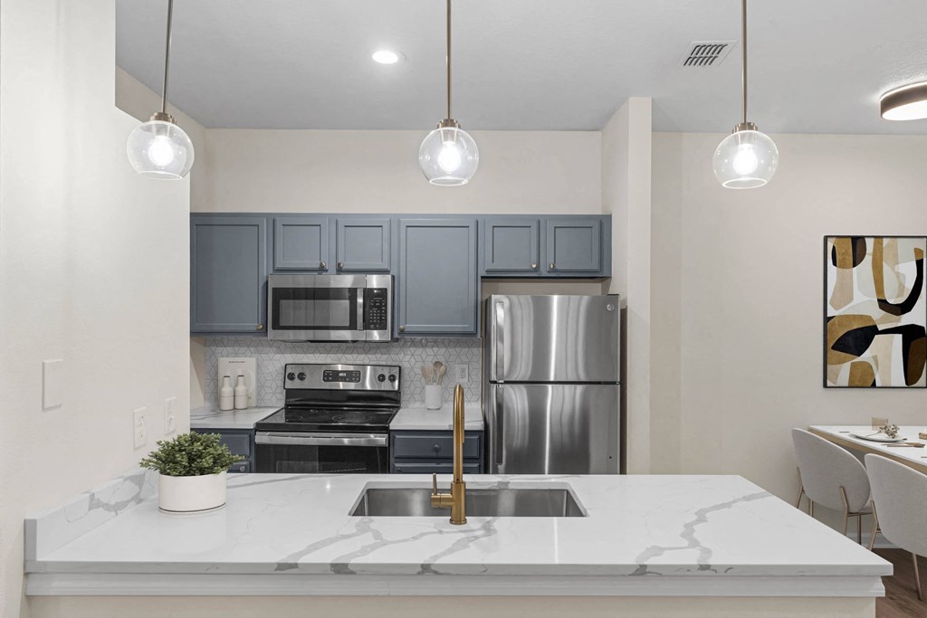 a kitchen with stainless steel appliances and a white counter top