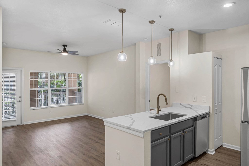 an empty kitchen and living room with a sink and refrigerator
