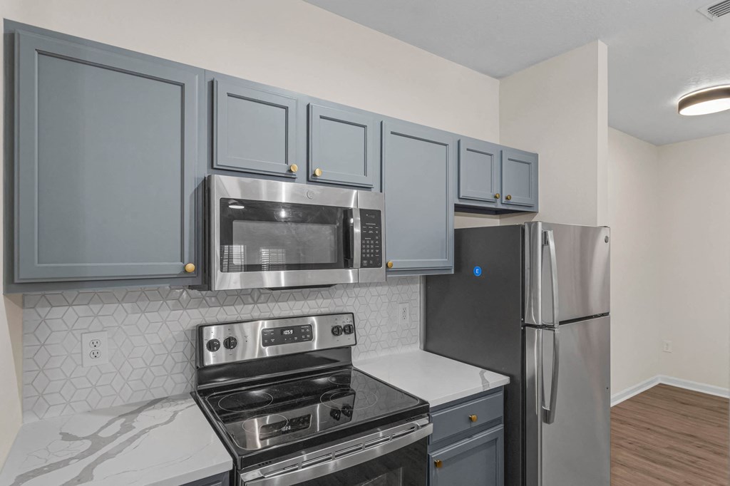 a kitchen with stainless steel appliances and blue cabinets