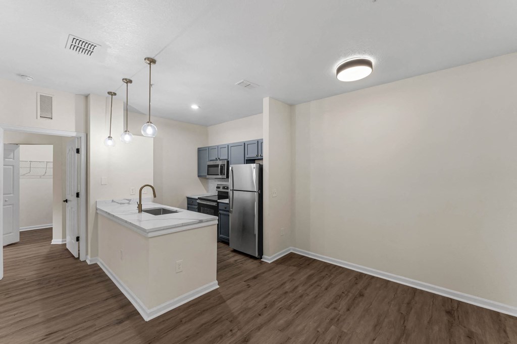 a renovated kitchen with an island and a stainless steel refrigerator
