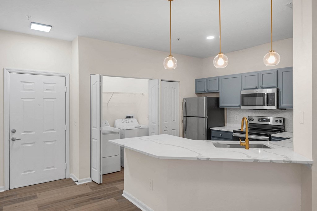 a kitchen with an island and a refrigerator and a sink