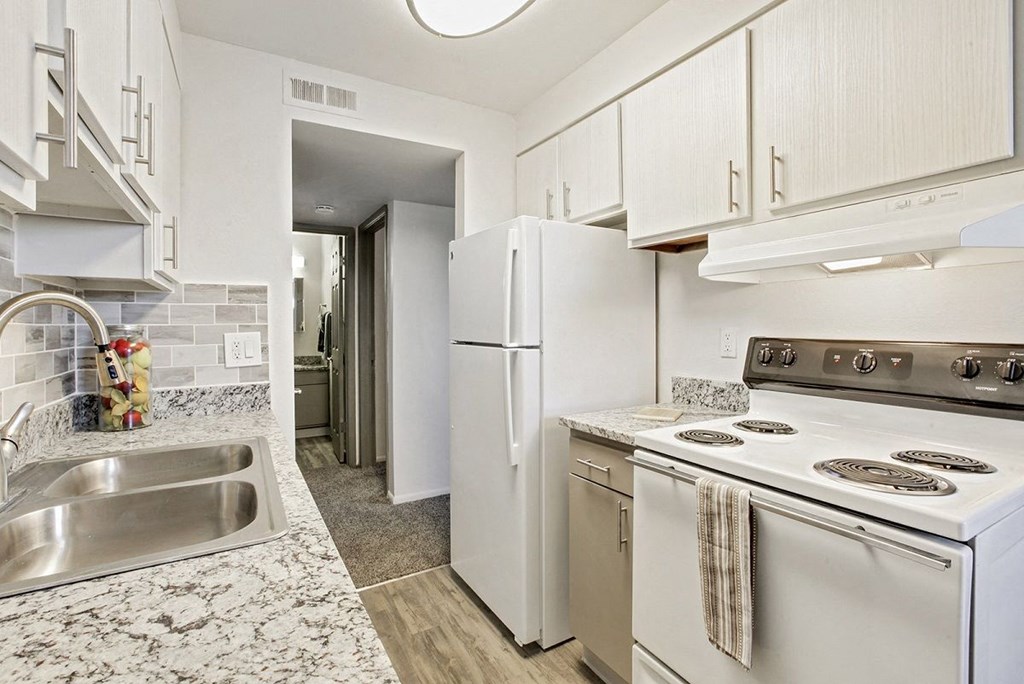 A kitchen with a white refrigerator and stove.