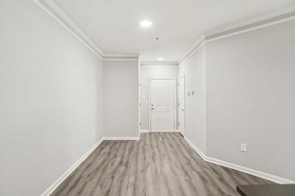 A room with a white door and a light on the ceiling.