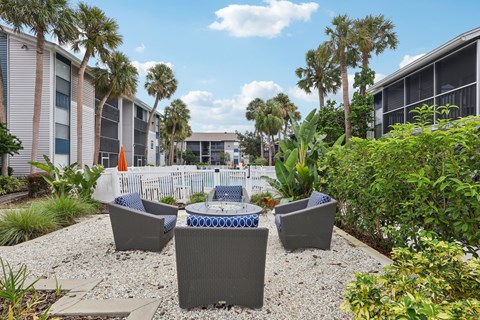 A patio area with grey furniture and a white fence.