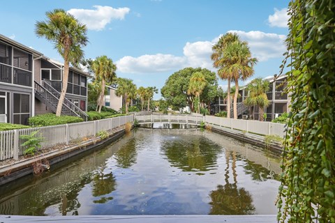 A canal with buildings on either side and a clear blue sky.