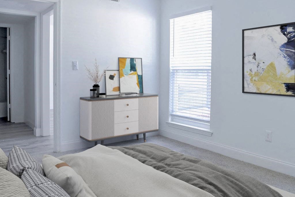 a bedroom with a bed and a dresser in front of a window