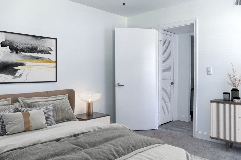 a bedroom with a bed and a nightstand with a lamp