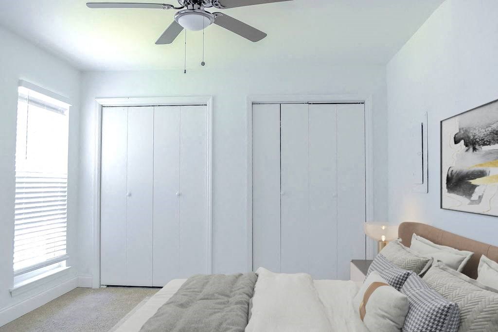 a bedroom with a bed and a ceiling fan