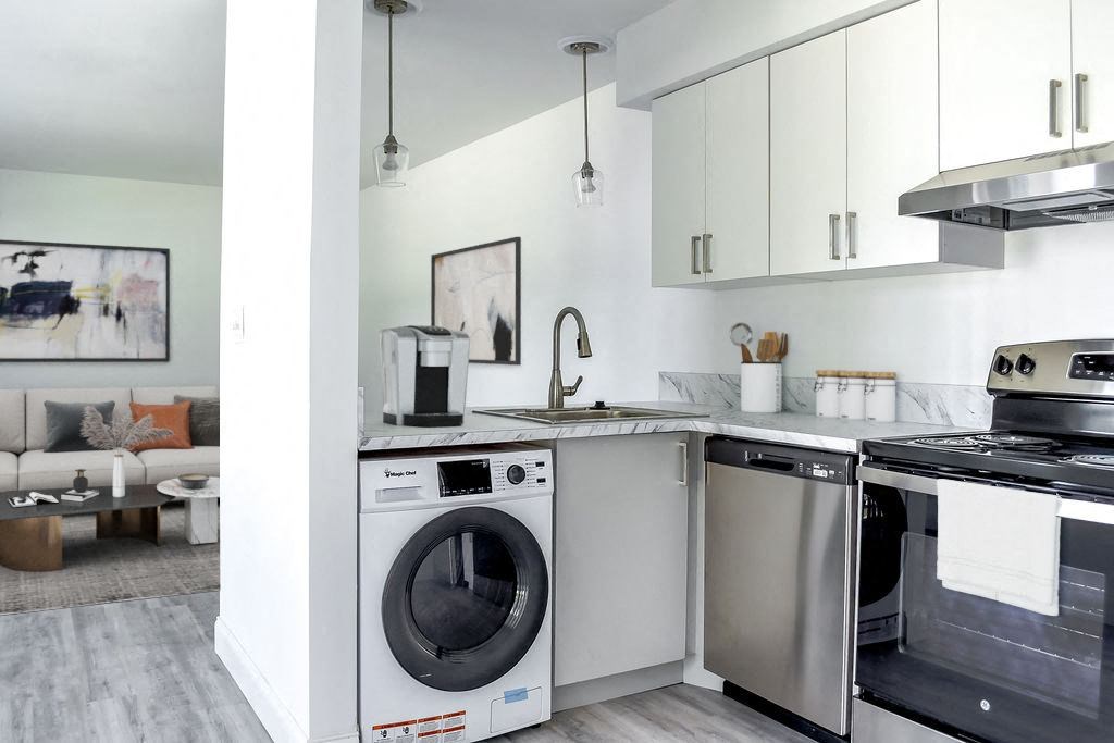 a white kitchen with stainless steel appliances and white cabinets