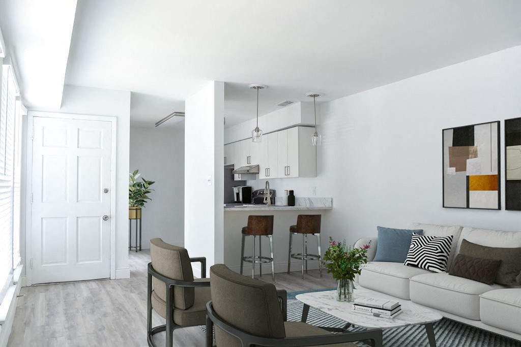 a living room with white walls and a white couch with a coffee table in front of it