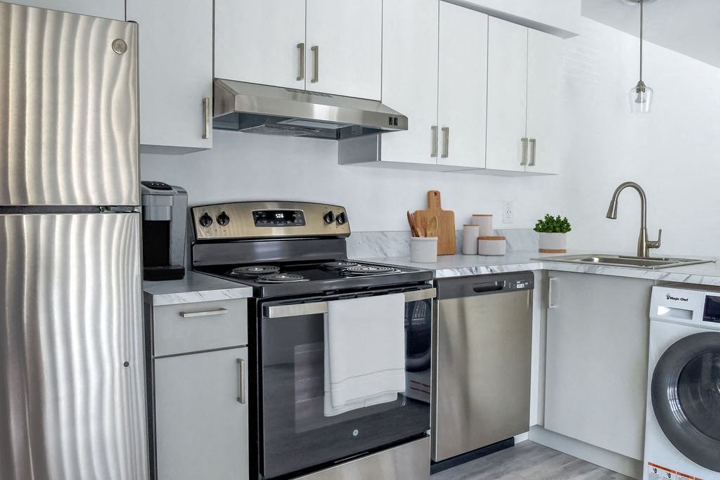 a kitchen with white cabinets and stainless steel appliances