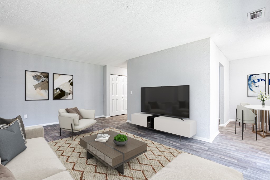 a living room with a large tv on the wall and a coffee table in the middle of