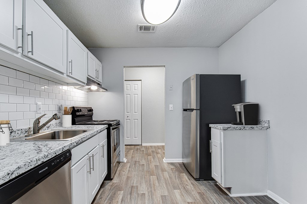 a kitchen with white cabinets and a stainless steel refrigerator