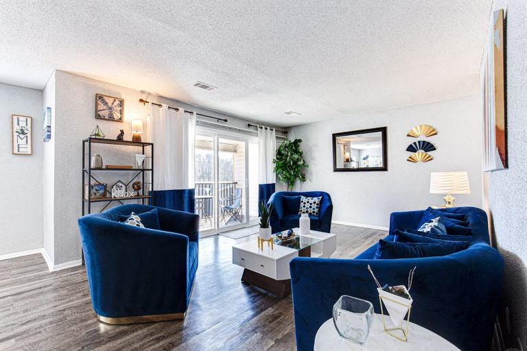 a living room with blue furniture and a sliding glass door