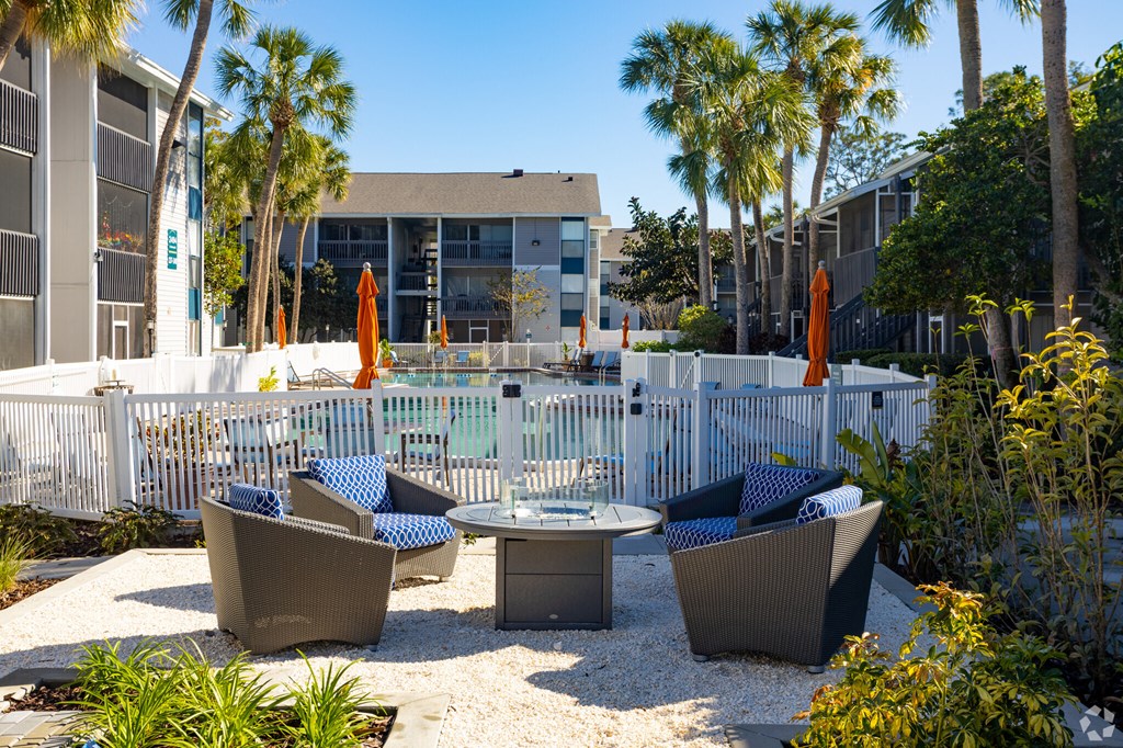 an outdoor patio with chairs and tables next to a pool