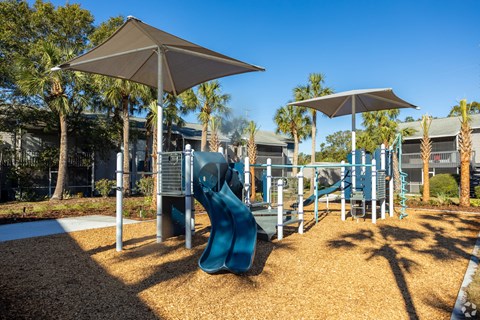 a playground with a slide and two umbrellas