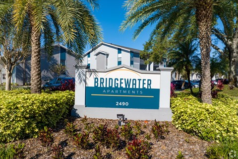 the entrance to bridgewater apartments sign in front of palm trees