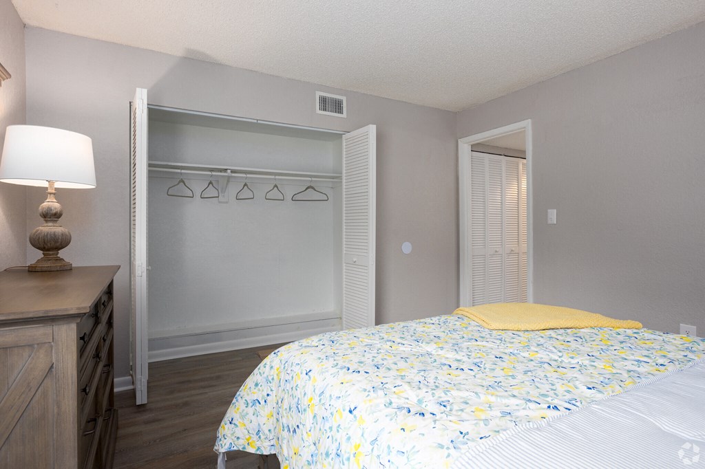 a bedroom with a yellow and white bed and a closet