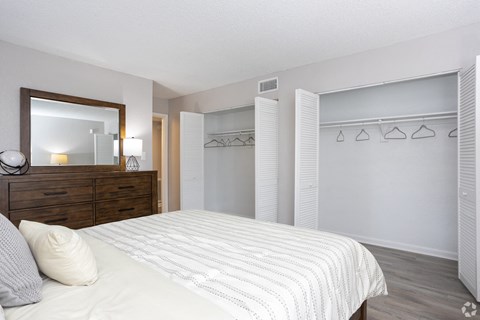 a bedroom with a large bed and a closet with a mirror