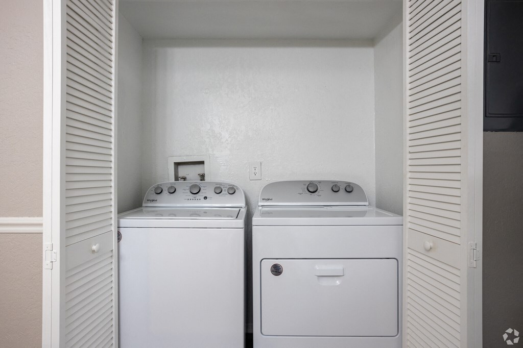 an empty laundry room with two washes and a dryer