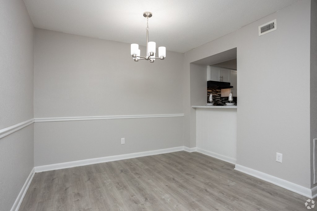 an empty living room with white walls and wood flooring
